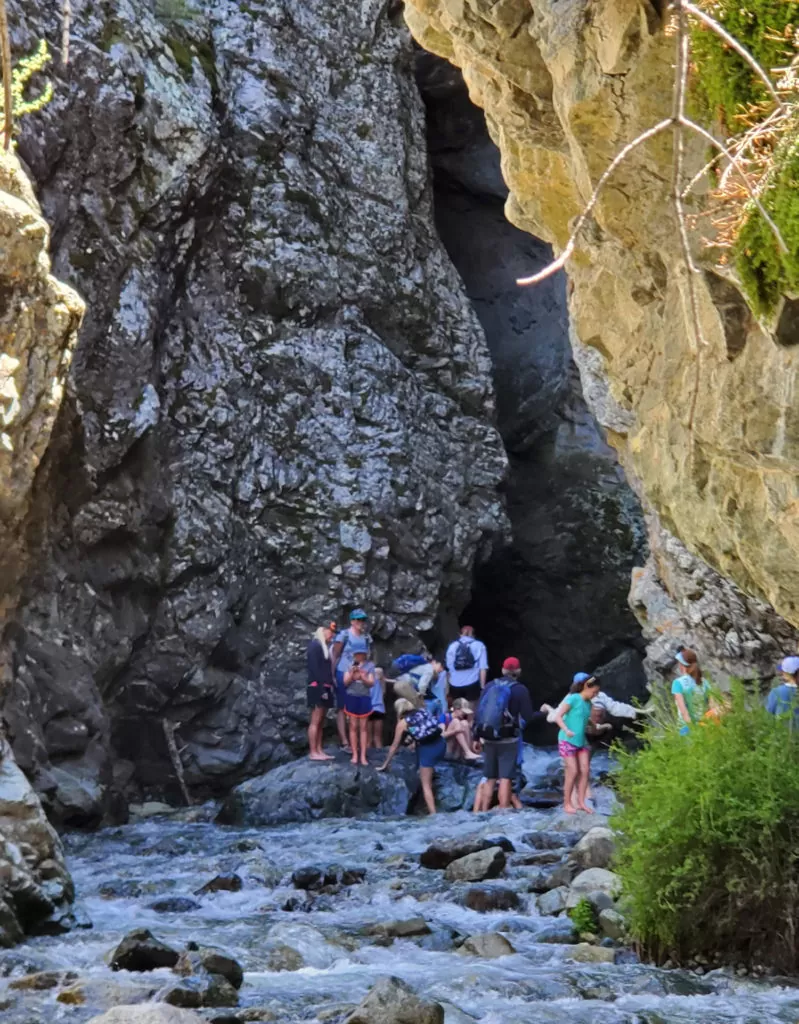 Attempting to warm up feet on a large rock in the river before entering the cave to see Zapata Falls