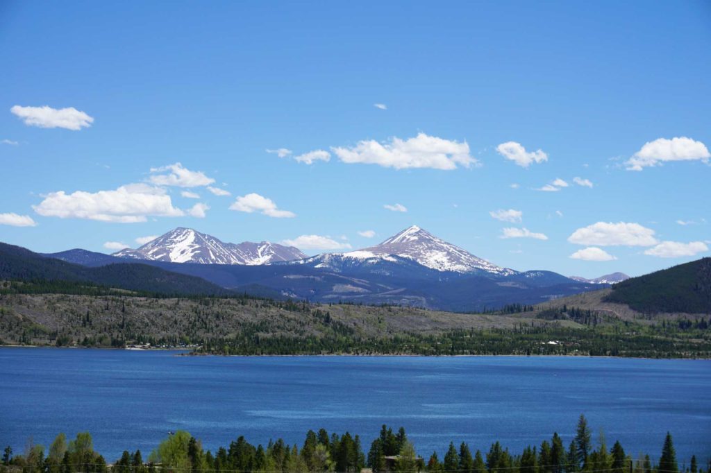 Réservoir de Dillon en été, avec des montagnes enneigées en arrière-plan.