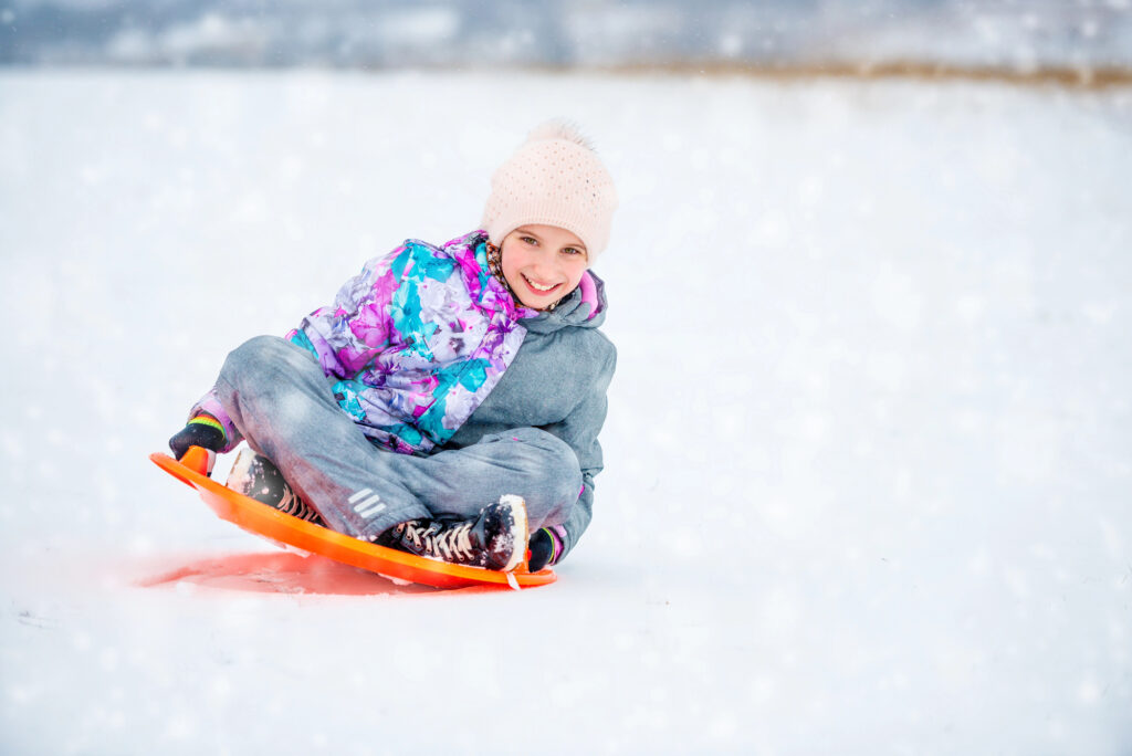 kid smiling while sledding