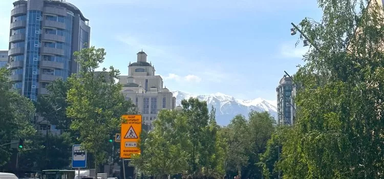 An Almaty Kazakhstan Adventure mountains in the background of a street in almaty kazakhstan